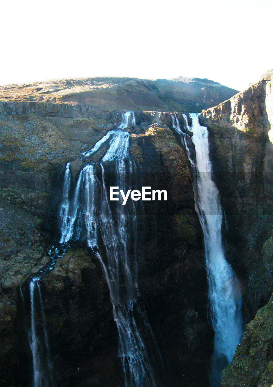 SCENIC VIEW OF WATERFALL ON CLIFF