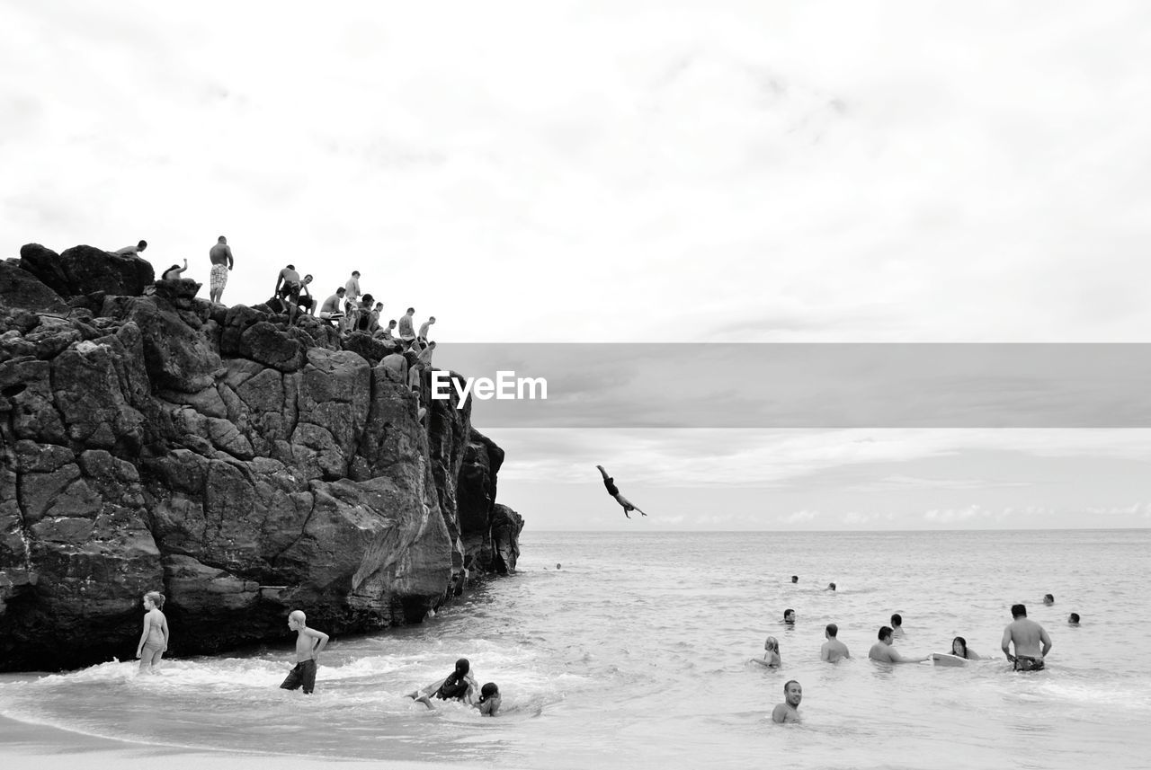 People enjoying in sea against sky