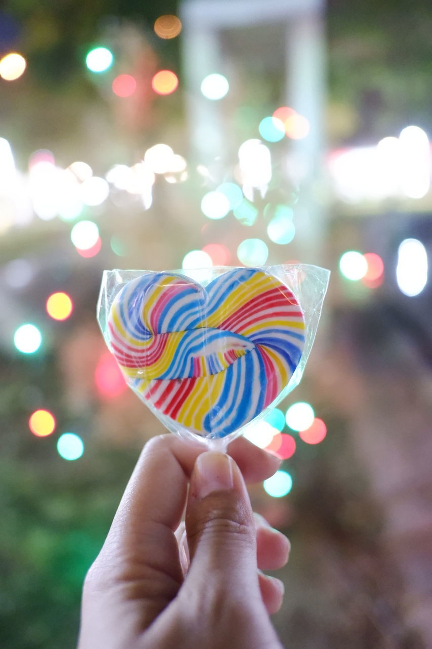 Close-up of hand holding multi colored candies