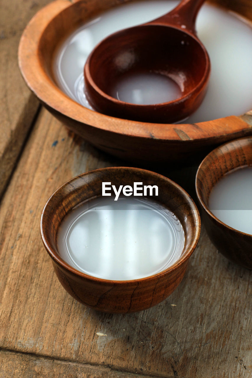 Sikhye or dongdongju, korean sweet rice drink, served on wooden bowl