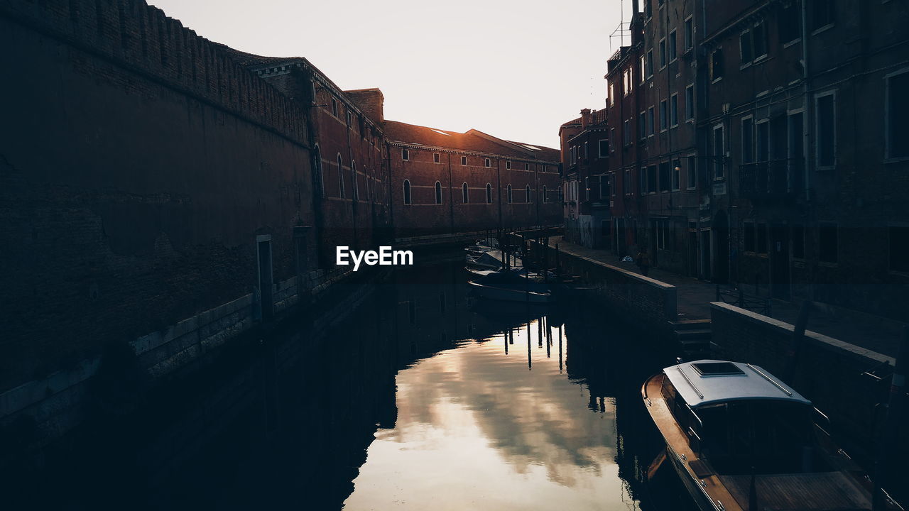 CANAL AMIDST BUILDINGS AGAINST SKY