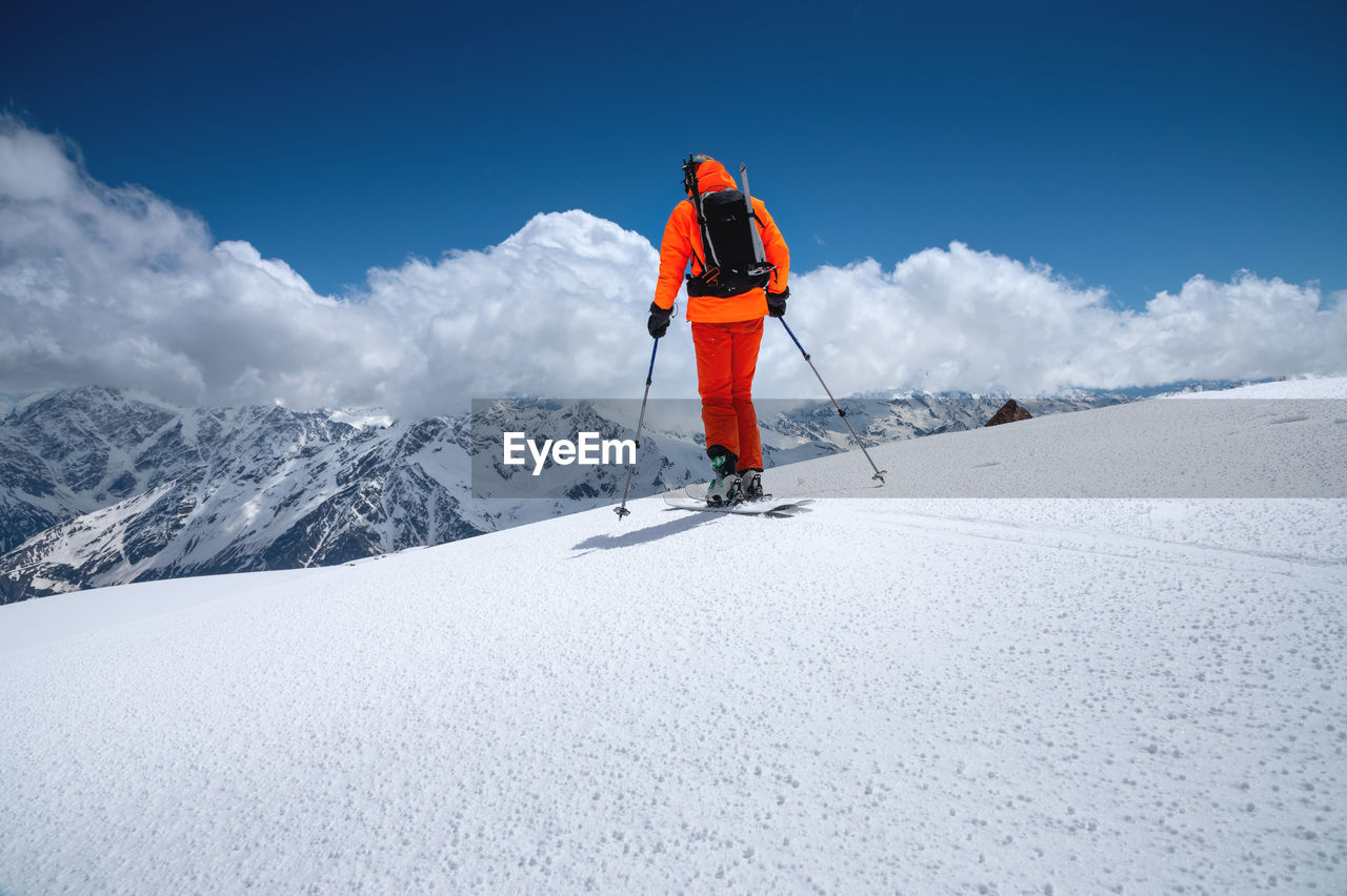 Portrait of a young male athlete skier in a ski tour on skis on the background of snow-capped