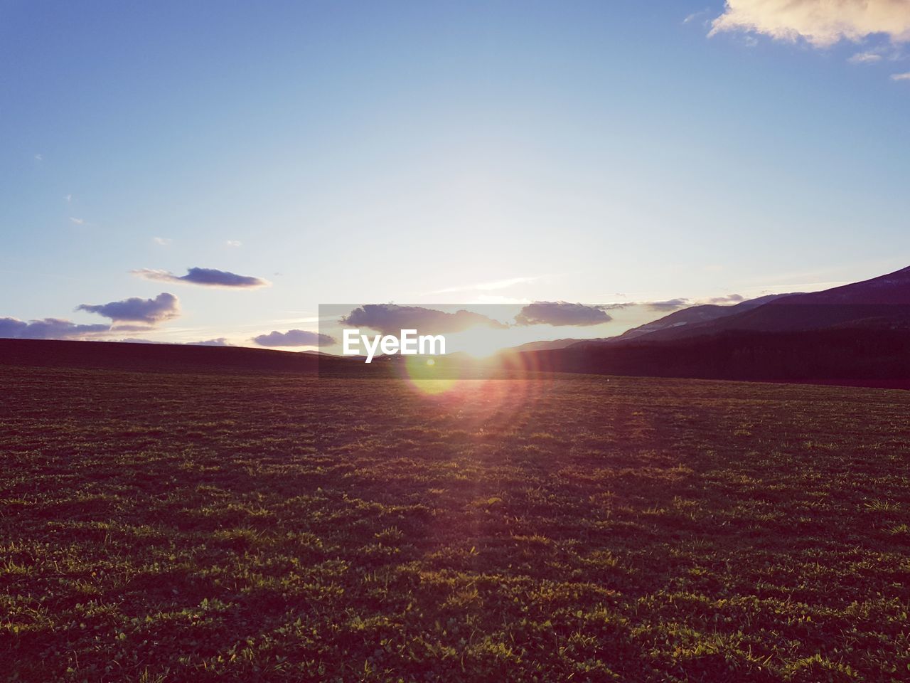 Scenic view of field against sky during sunset