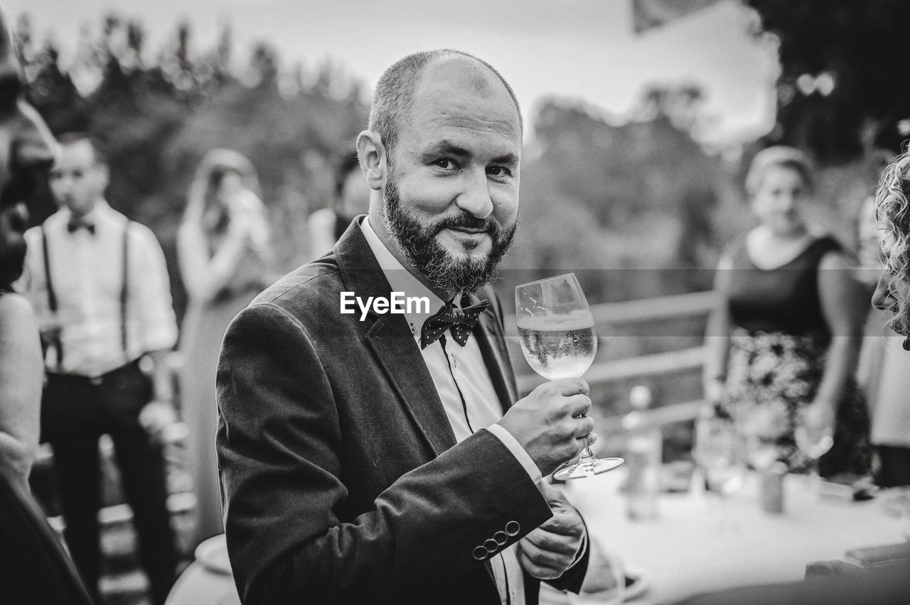 Portrait of smiling man holding alcoholic drink during party