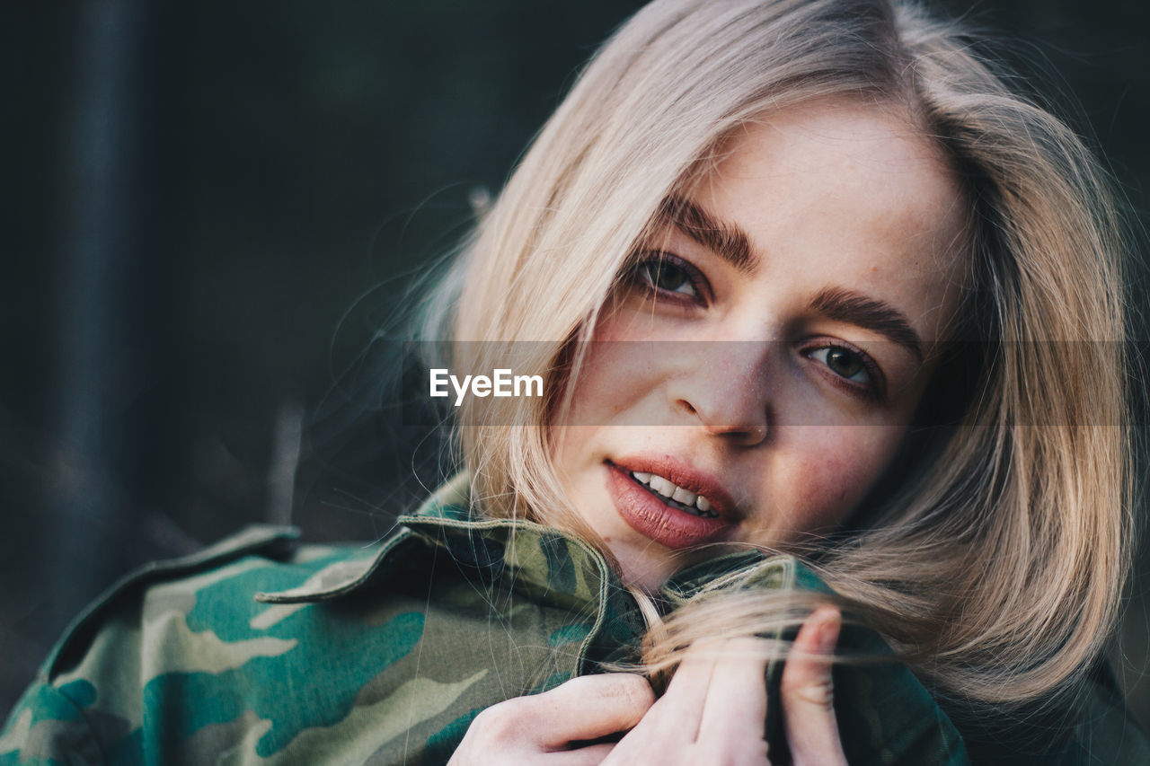 Close-up portrait of young woman wearing camouflage clothing