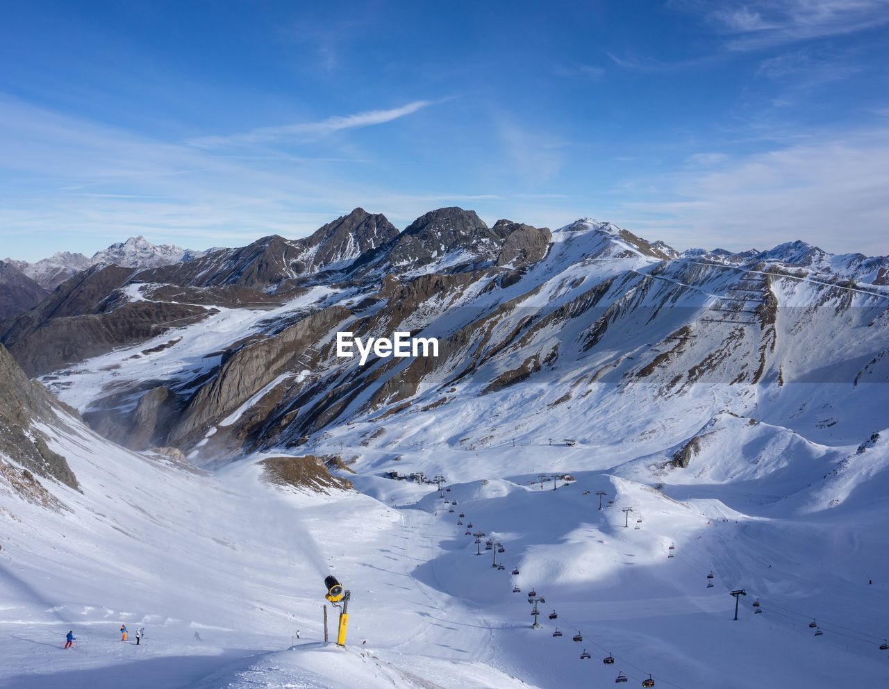 Scenic view of snowcapped mountains against sky with a snowgun in ischgl