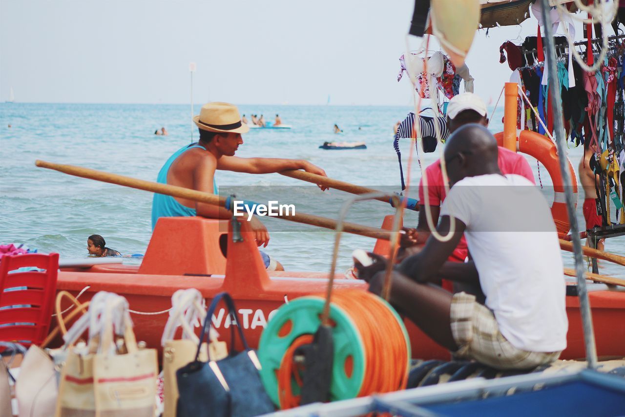 VIEW OF SEA WITH PEOPLE IN BACKGROUND