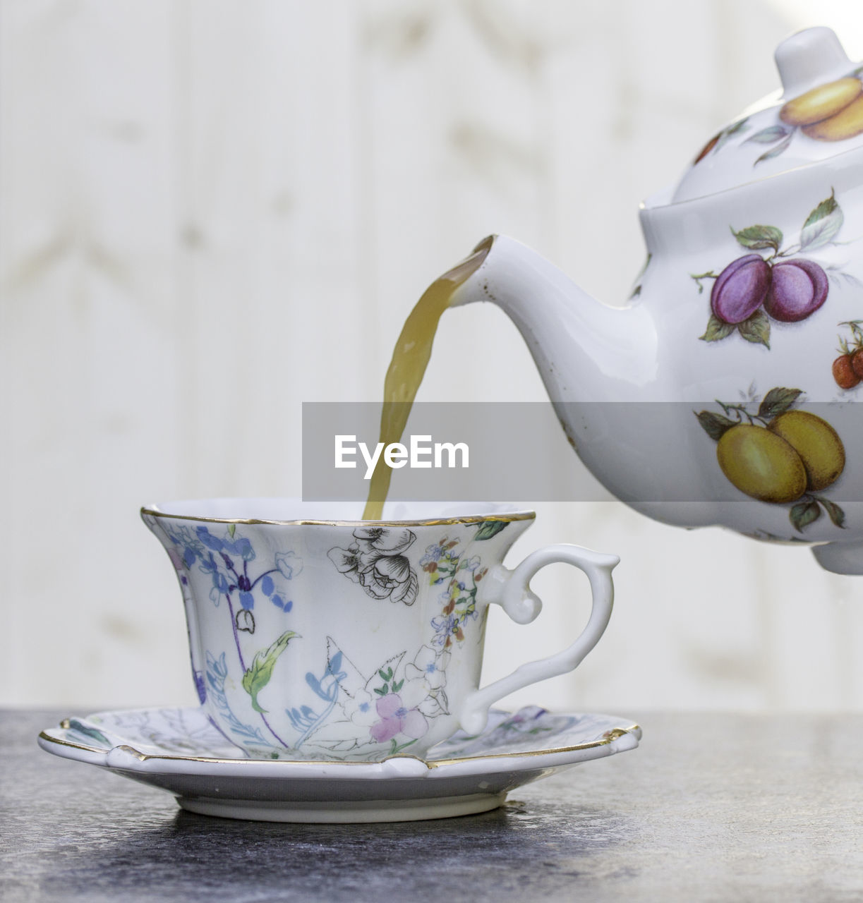 Close-up of tea being poured into a tea cup on table