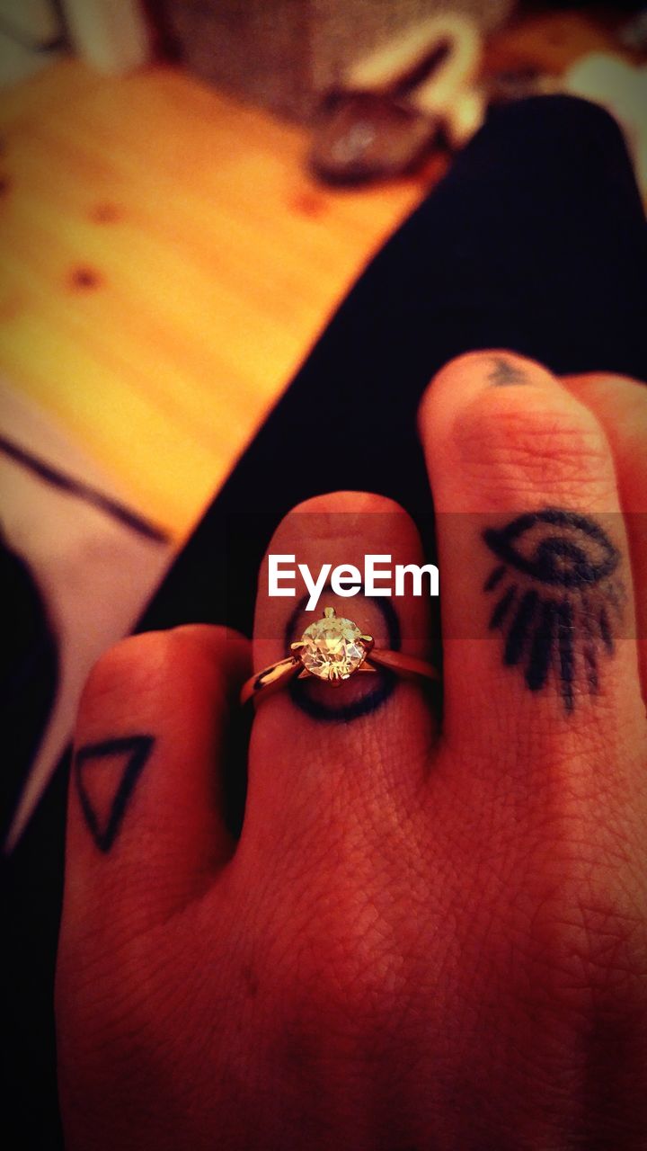 Cropped hand of woman with wedding ring at home