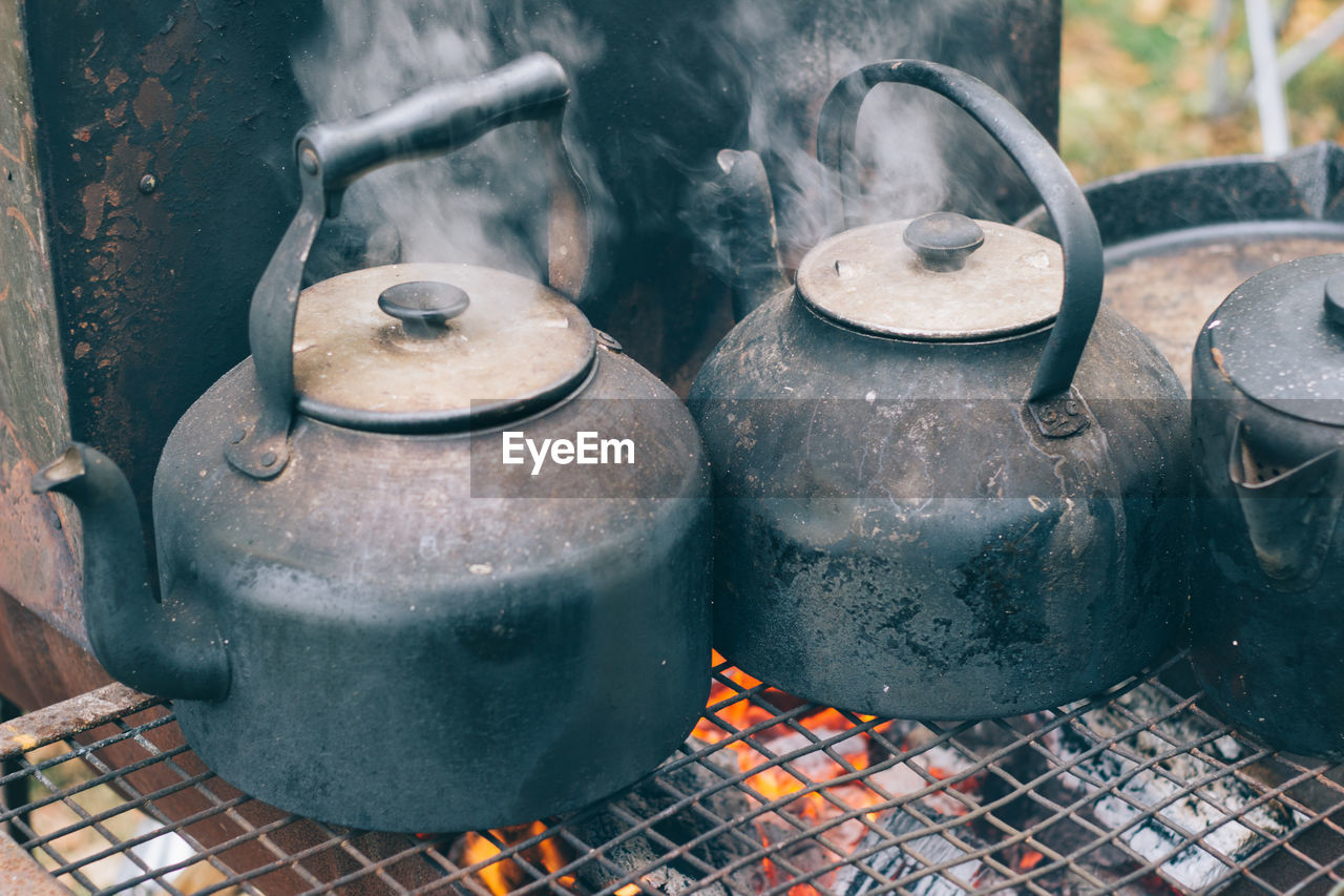 Close-up of rusty metal container on wood burning stove