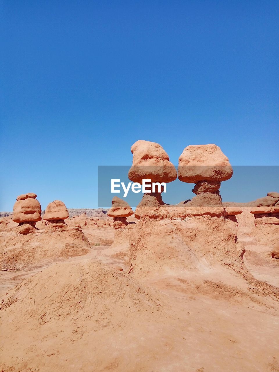 Rocks in desert against clear blue sky