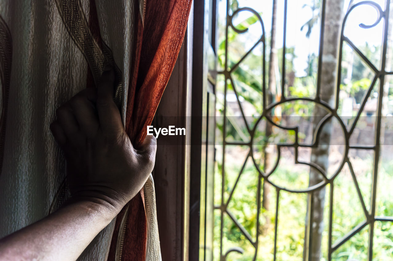 CLOSE-UP OF HAND AGAINST WINDOW