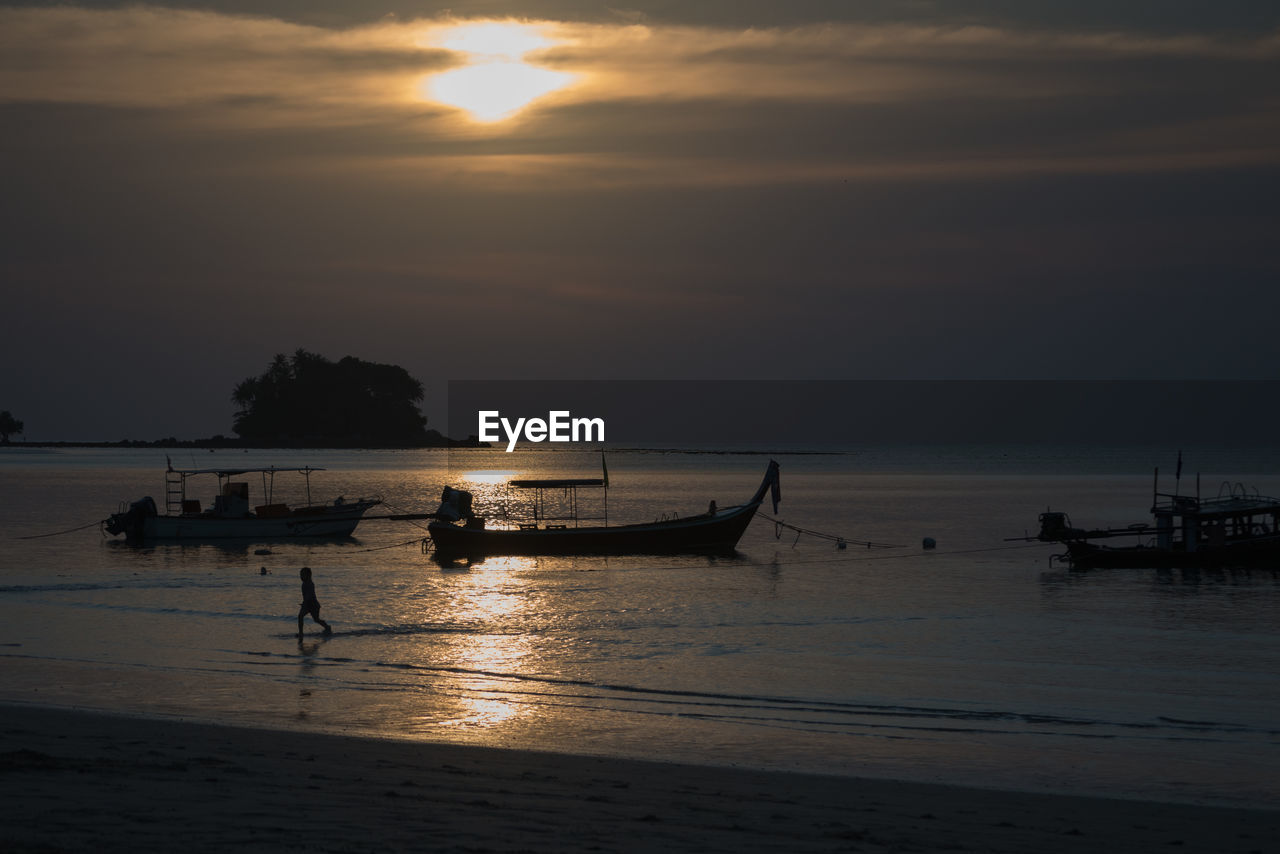 SILHOUETTE BOATS IN SEA AGAINST ORANGE SKY