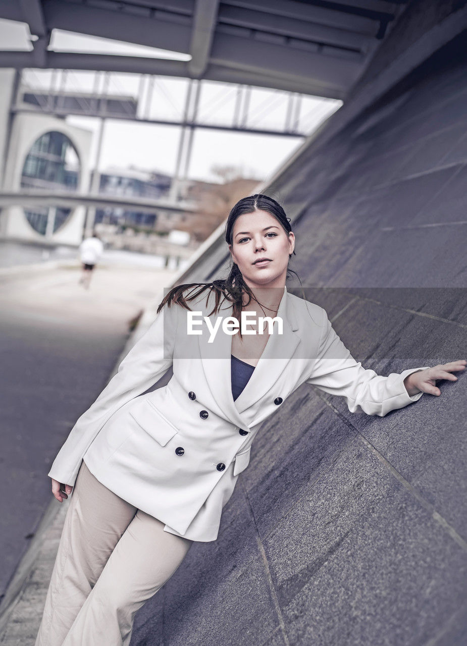 portrait of smiling young woman standing in city