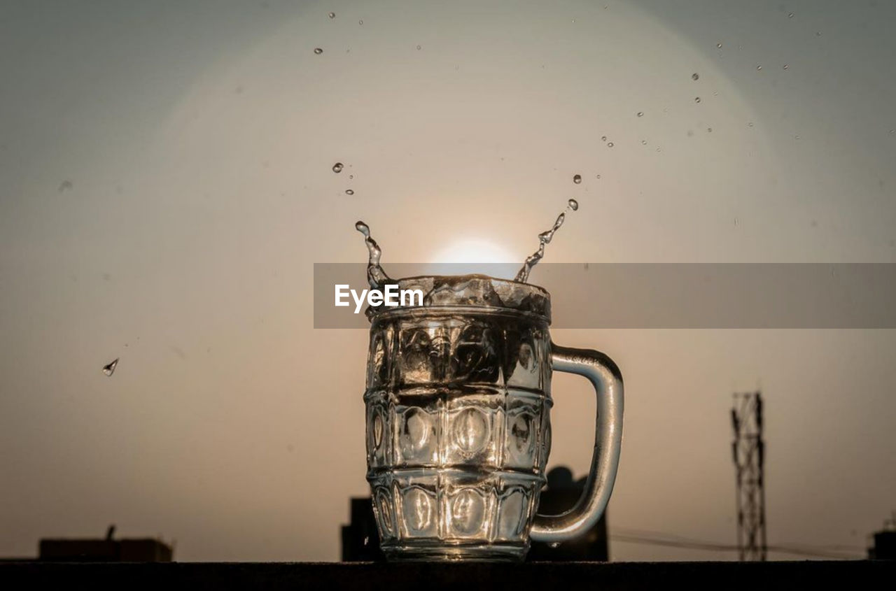 CLOSE-UP OF COFFEE CUP ON TABLE AGAINST CLEAR SKY