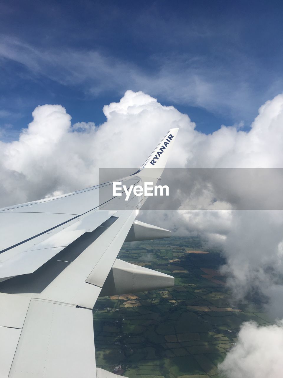 CLOSE-UP OF AIRPLANE WING AGAINST CLOUDS