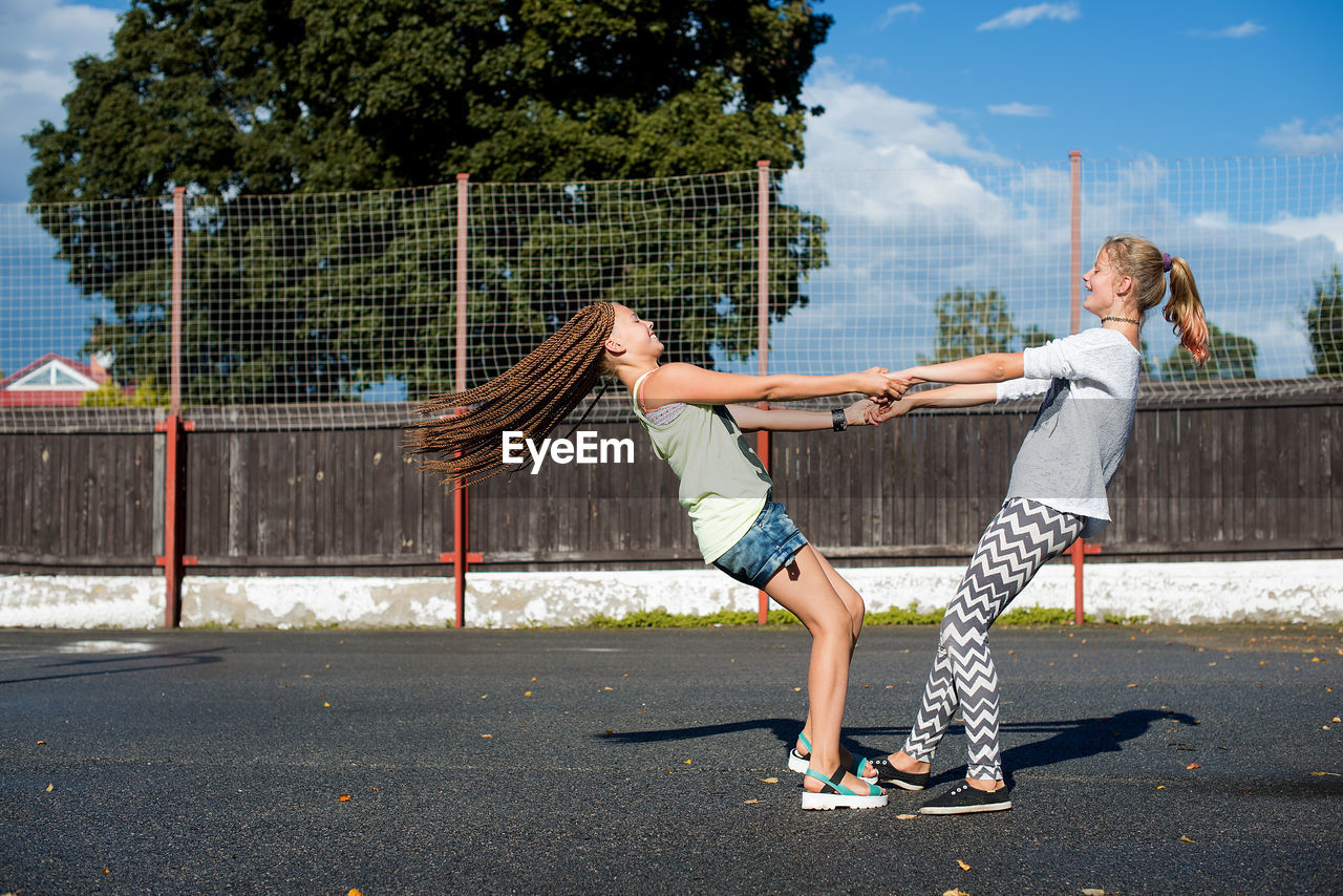 Side view of female friends playing at playground