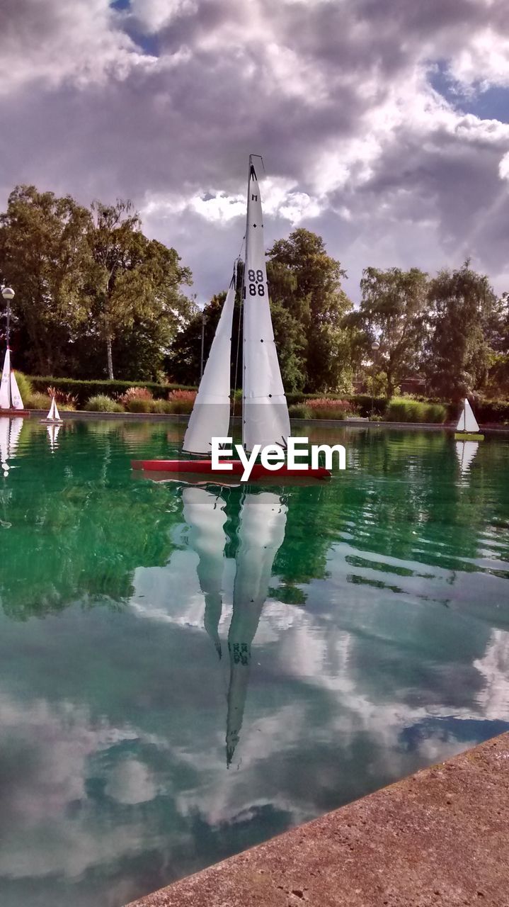 Artificial sail boats floating on lake at park