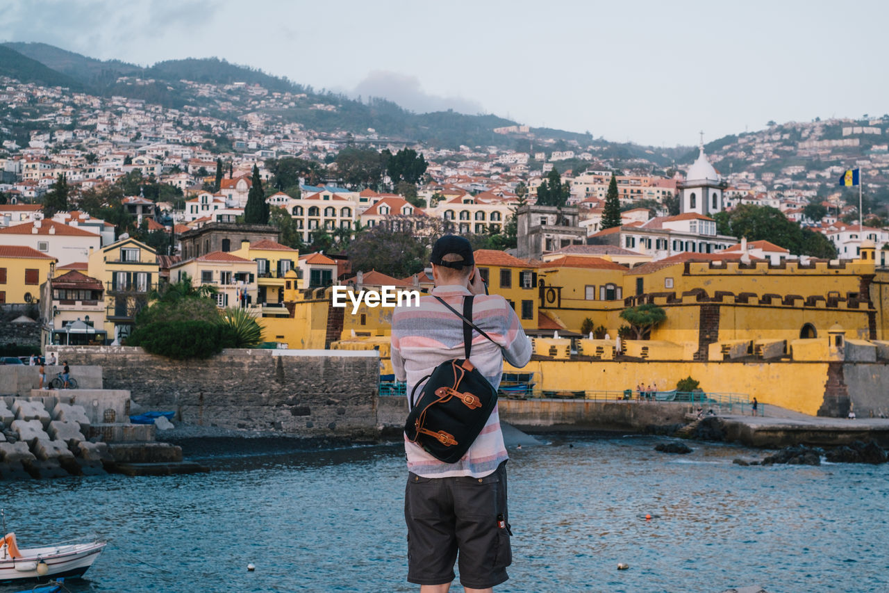 Rear view of man looking at townscape