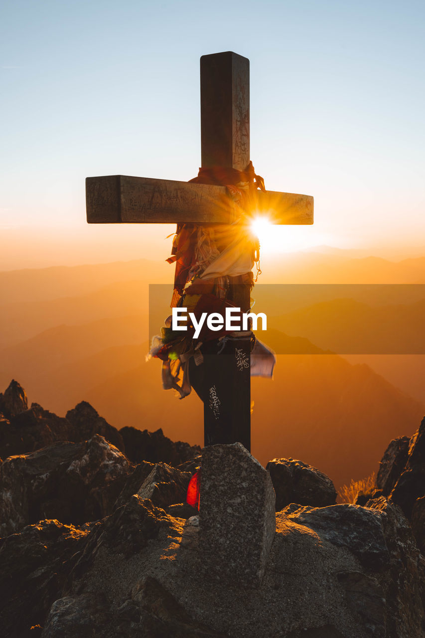 A cross at the summit of mont valier, pyrenees at sunrise.