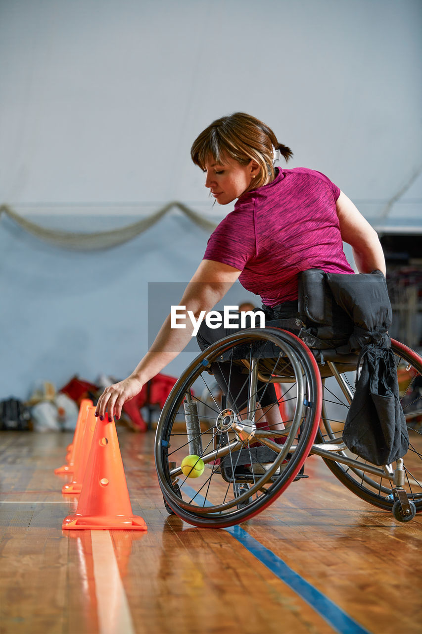 side view of young woman riding bicycle on floor