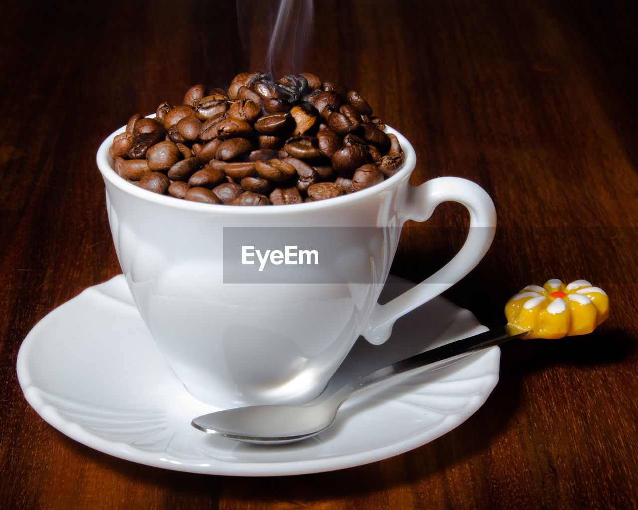 Close-up of roasted coffee beans in cup on table