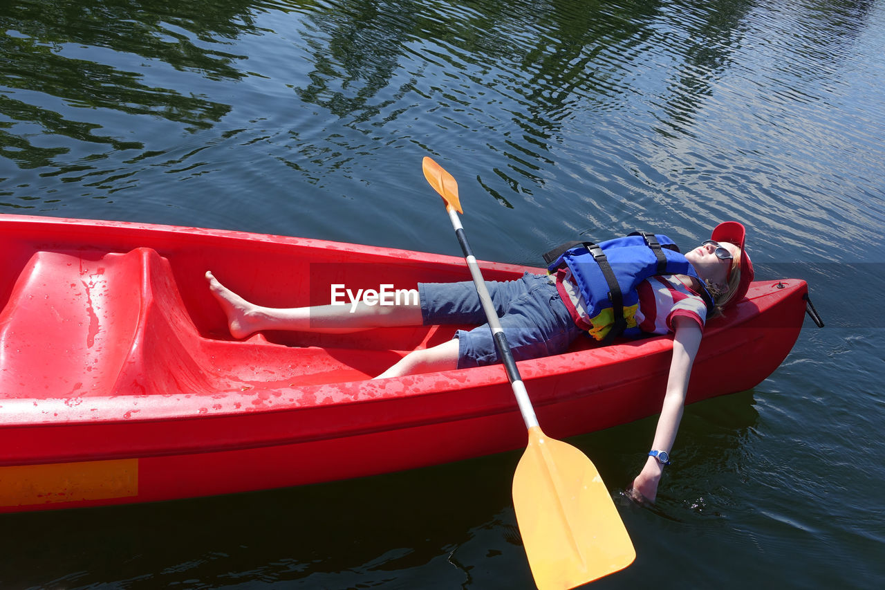 Worn out, child lying down in canoe on a hot summers day