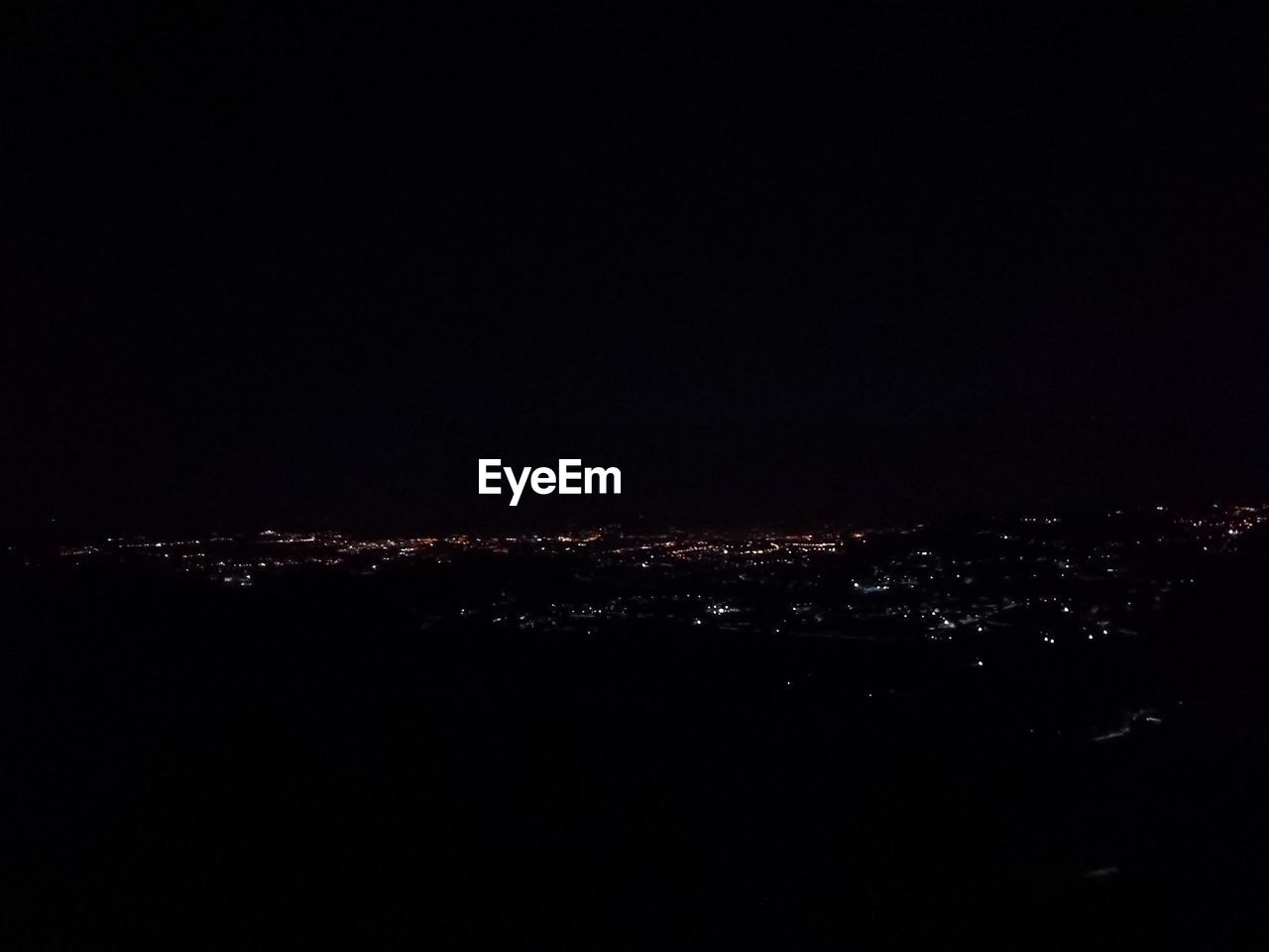 ILLUMINATED CITYSCAPE AGAINST SKY