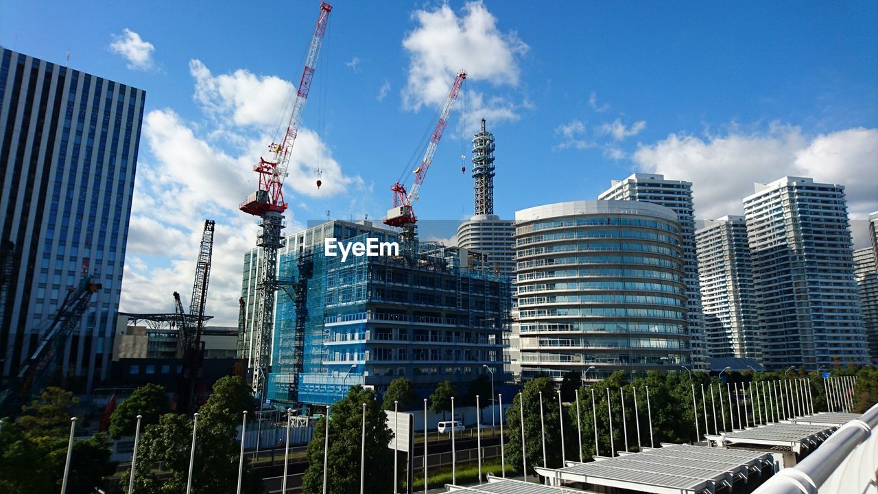 Modern buildings and crane in city against sky