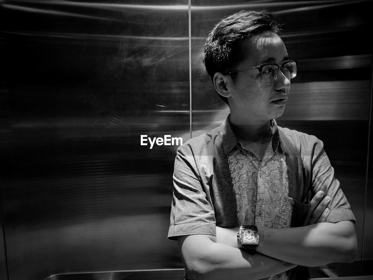 Young man looking away while standing in elevator