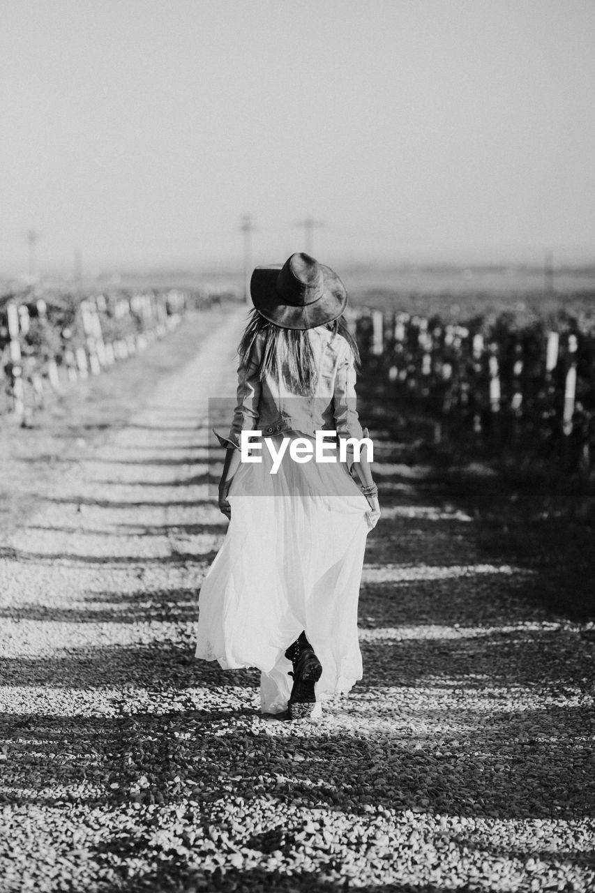 Women walking alone in a winery filed at sunset