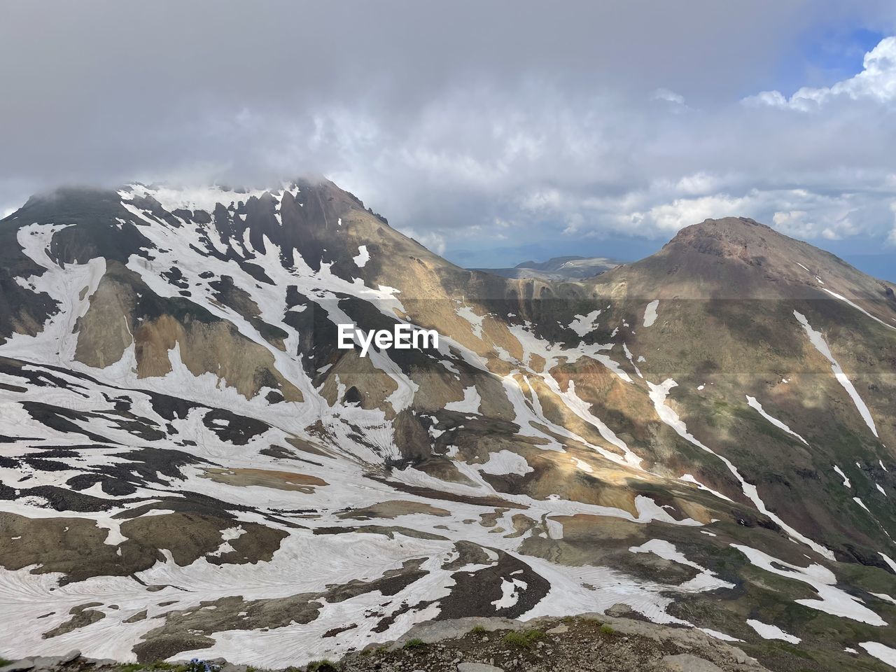 mountain, environment, landscape, scenics - nature, snow, sky, mountain range, cloud, cold temperature, beauty in nature, winter, nature, wilderness, ridge, snowcapped mountain, mountain pass, travel, travel destinations, land, adventure, no people, activity, plateau, mountain peak, cirque, leisure activity, outdoors, tranquility, non-urban scene, summit, tranquil scene, day, rock, tourism, ice, social issues, extreme terrain, fog, moraine, valley