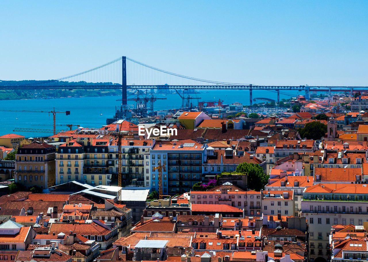 High angle view of buildings by april 25th bridge over tagus river