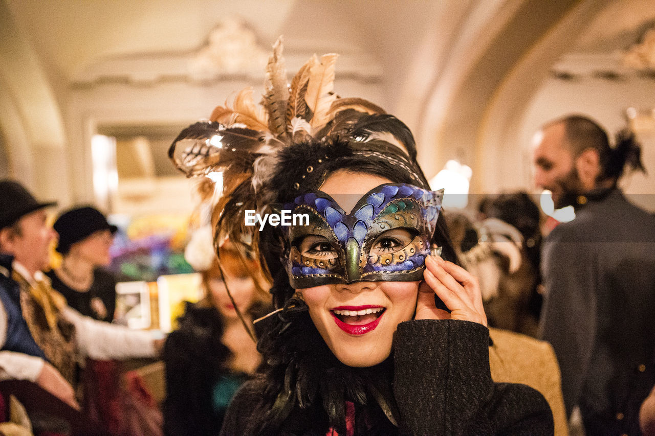 Portrait of happy woman wearing masquerade mask at party