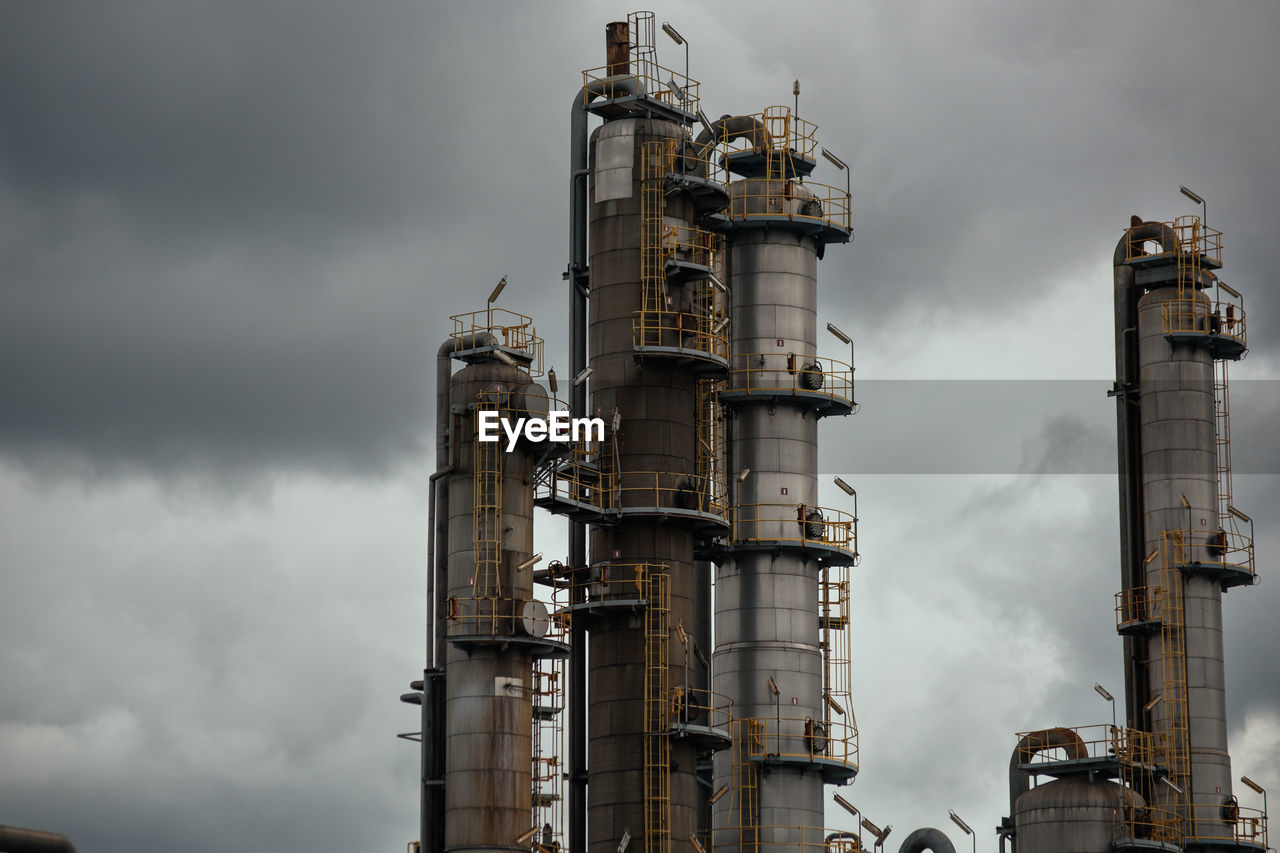 LOW ANGLE VIEW OF FACTORY AGAINST CLOUDY SKY