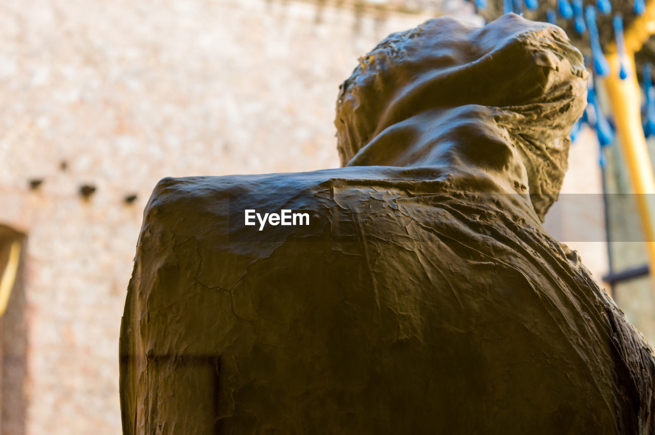 CLOSE-UP OF A STATUE AGAINST WALL