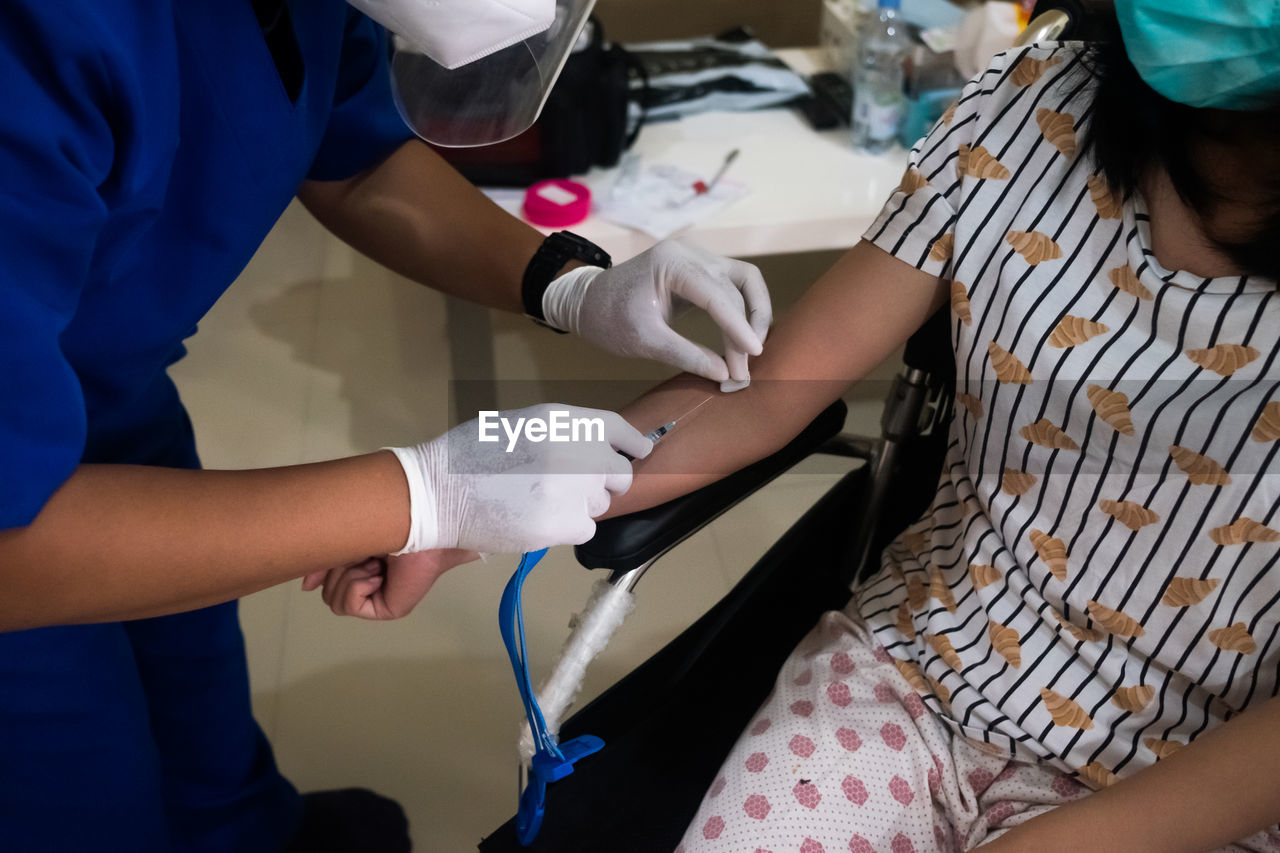 Rear view of mother with hands, blood transfusion, healthcare 