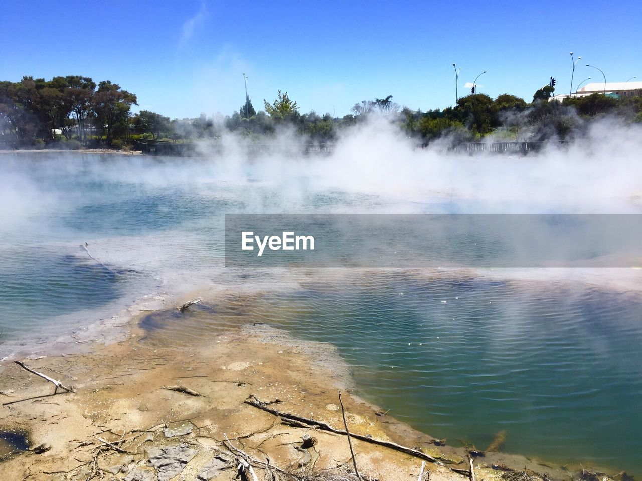 Scenic view of steam emitting from geyser against sky