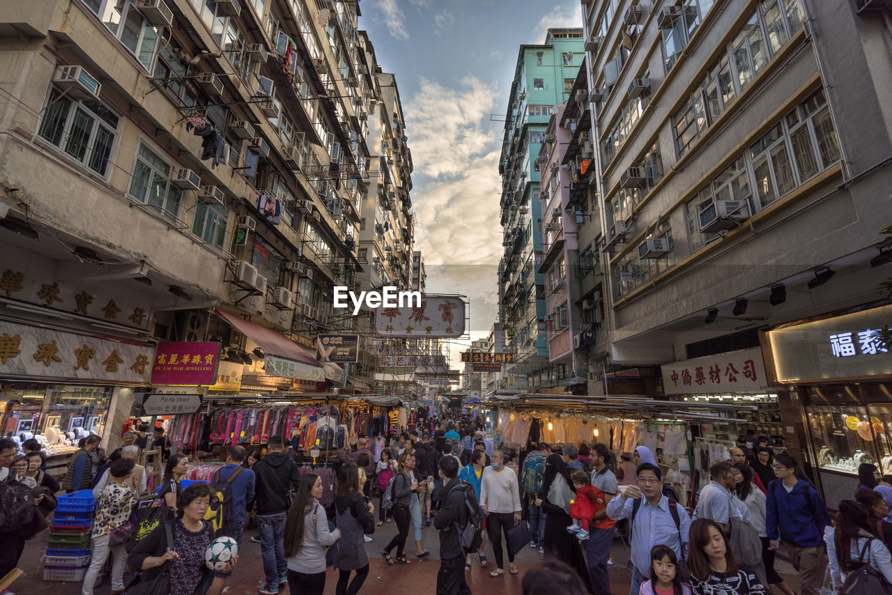 People walking on street amidst buildings in city