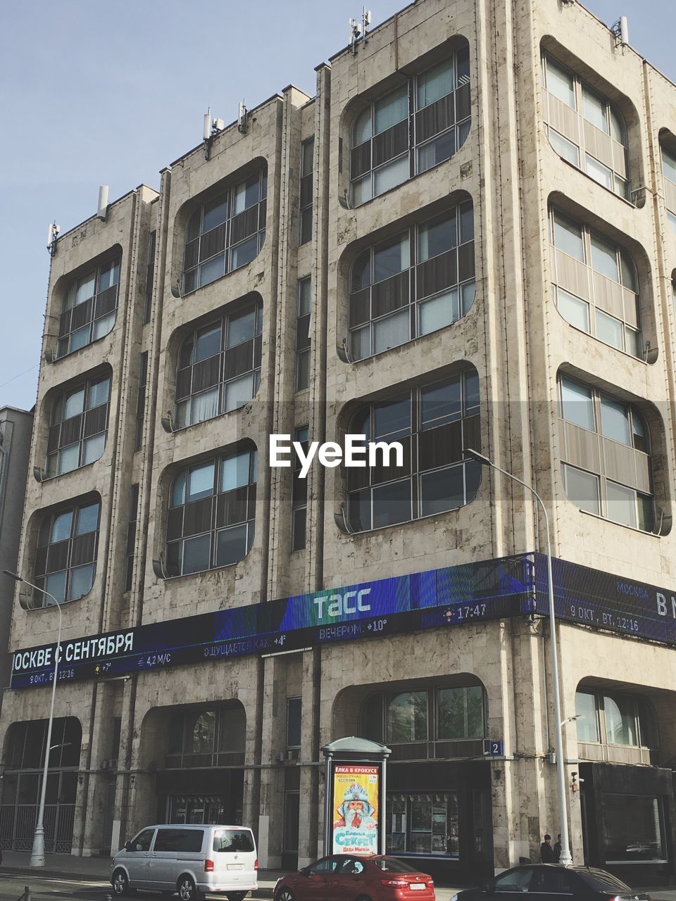 LOW ANGLE VIEW OF BUILDING BY STREET AGAINST SKY