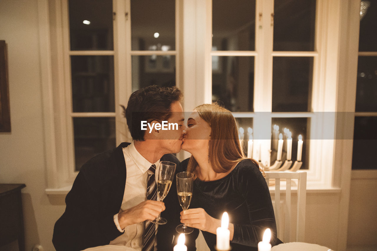 Kissing couple holding champagne flutes