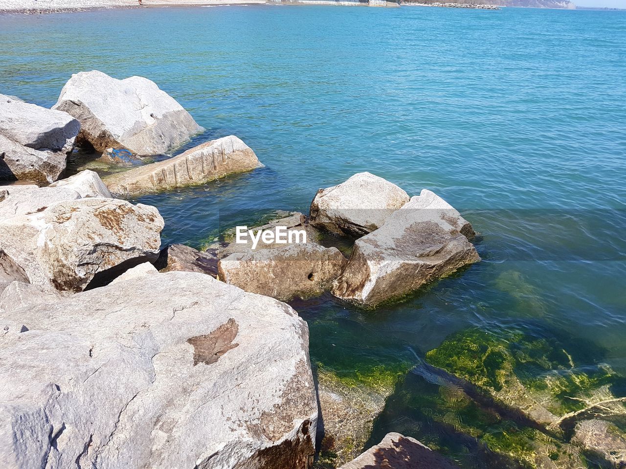 HIGH ANGLE VIEW OF ROCK FORMATIONS ON SEA