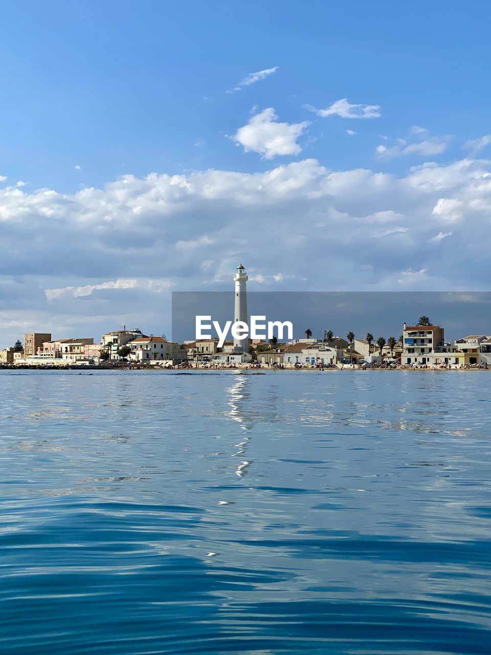 SEA BY BUILDINGS AGAINST SKY