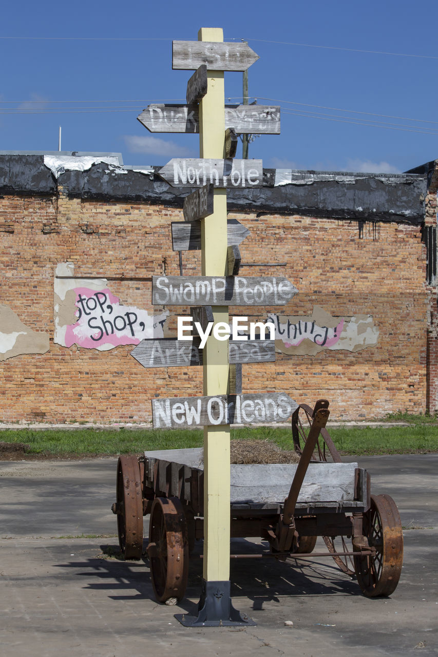 communication, sign, text, road, western script, transportation, day, road sign, guidance, nature, no people, architecture, sky, vehicle, arrow symbol, outdoors, information sign, street, city, directional sign, symbol, built structure