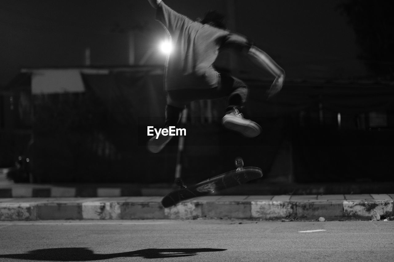 REFLECTION OF MAN SKATEBOARDING ON STREET