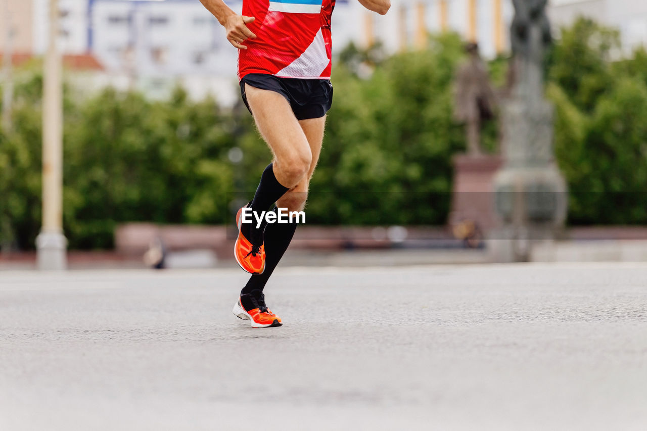 Man runner in black compression socks running city marathon