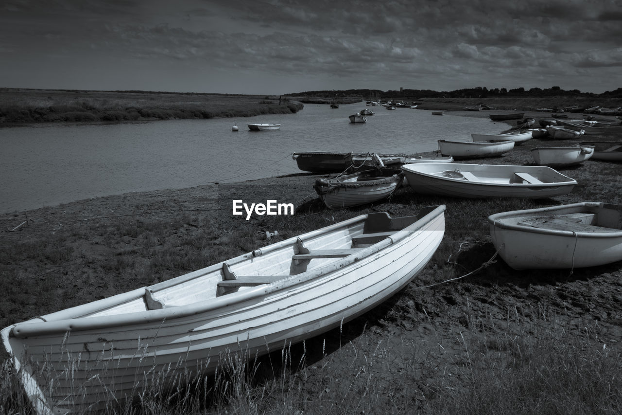 Boats moored on beach against sky