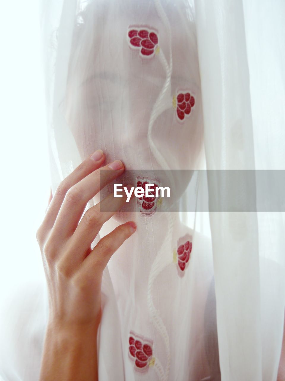 Woman seen through white curtain