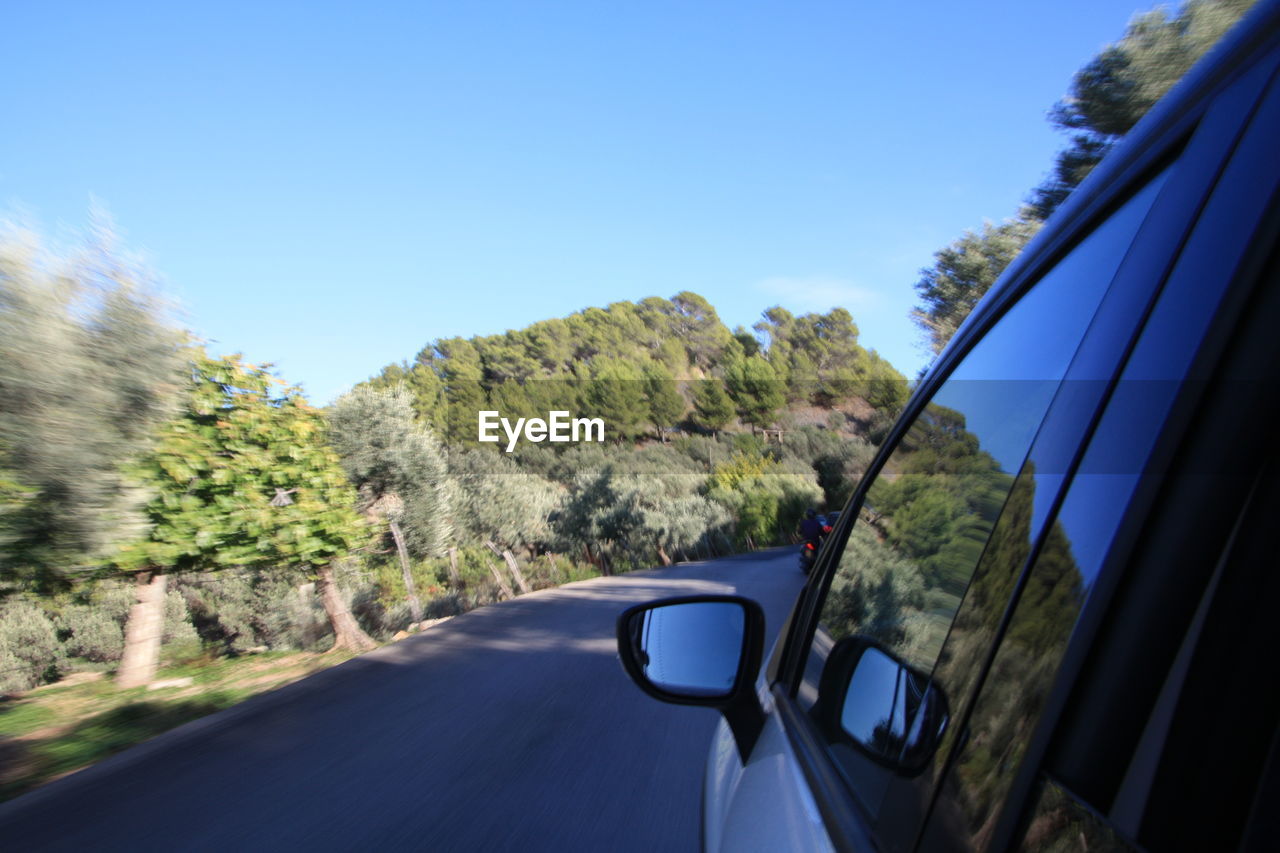 CARS ON ROAD AGAINST CLEAR BLUE SKY SEEN THROUGH CAR