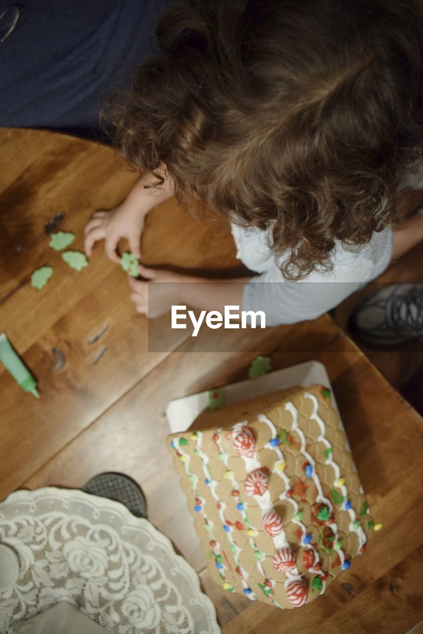 High angle view of girl sitting by table